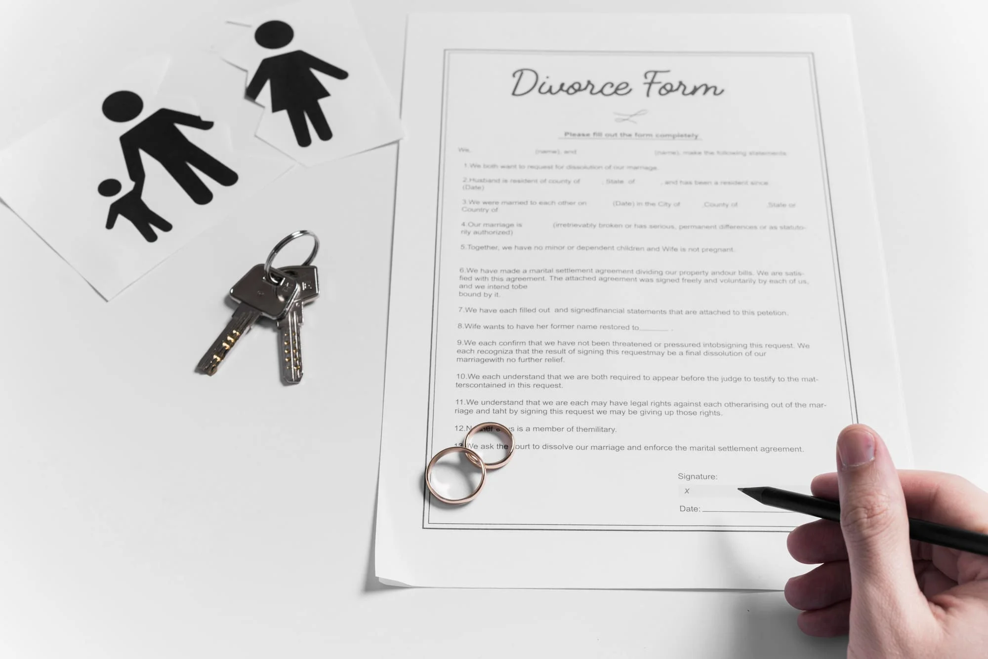 Divorce form with a pen, two wedding rings and house keys