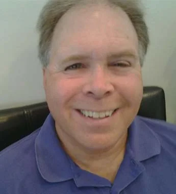 Portrait of Randy M. Sonns, smiling, in a blue polo shirt